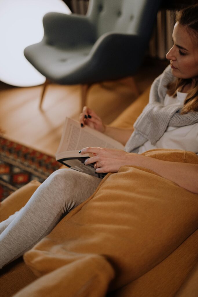 Woman enjoying a quiet evening reading in a warm, cozy living room.